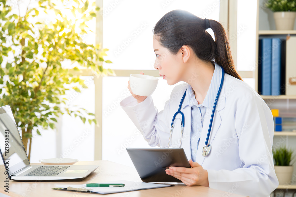 doctor drink coffee using digital tablet research patient's medi doctor drink coffee using digital tablet research patient's medi