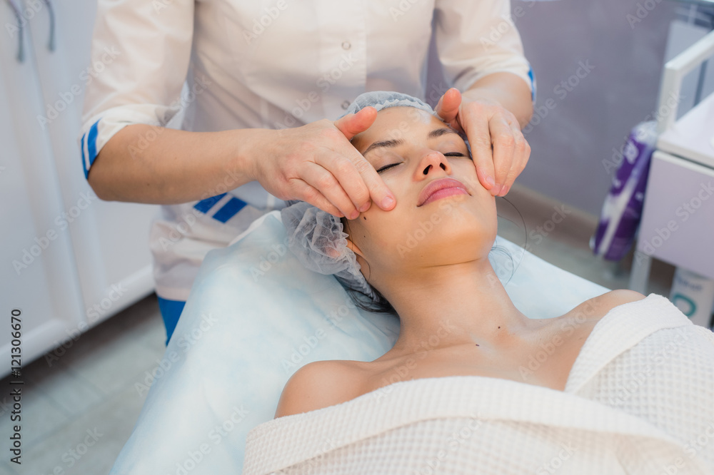 Beautiful young woman relaxing with face massage at beauty spa Beautiful young woman relaxing with face massage at beauty spa