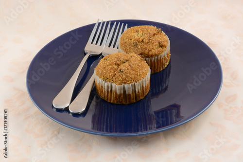 Breakfast for two:  raisin muffins with two forks on one plate