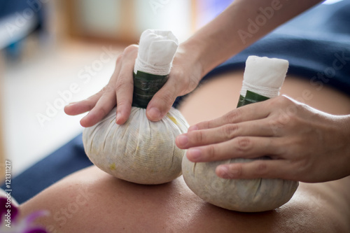 Принти на полотні woman getting thai herbal compress massage in spa