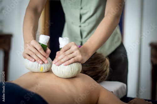 Принти на полотні woman getting thai herbal compress massage in spa