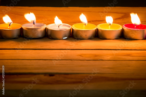 candle flames glowing in the dark. candle light on wooden table.