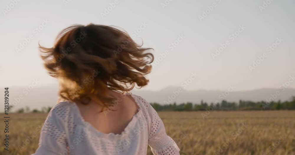 Beautiful girl running on sunlit wheat field. Slow motion 240 fps. Sun lens flare. Freedom concept. Happy woman having fun outdoors in a wheat field on sunset or sunrise.Harvest Beautiful girl running on sunlit wheat field. Slow motion 240 fps. Sun lens flare. Freedom concept. Happy woman having fun outdoors in a wheat field on sunset or sunrise.Harvest