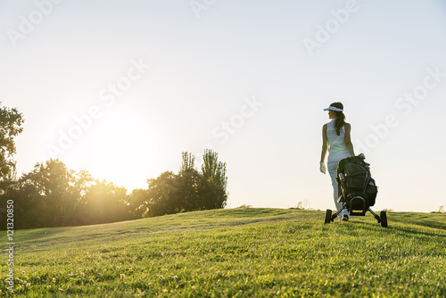 Pretty young woman playing golf.