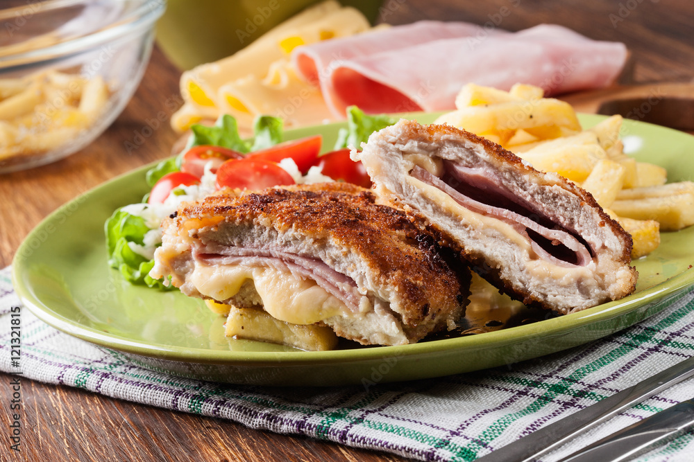 Cutlet Cordon Bleu with pork loin served with French fries and salad Cutlet Cordon Bleu with pork loin served with French fries and salad