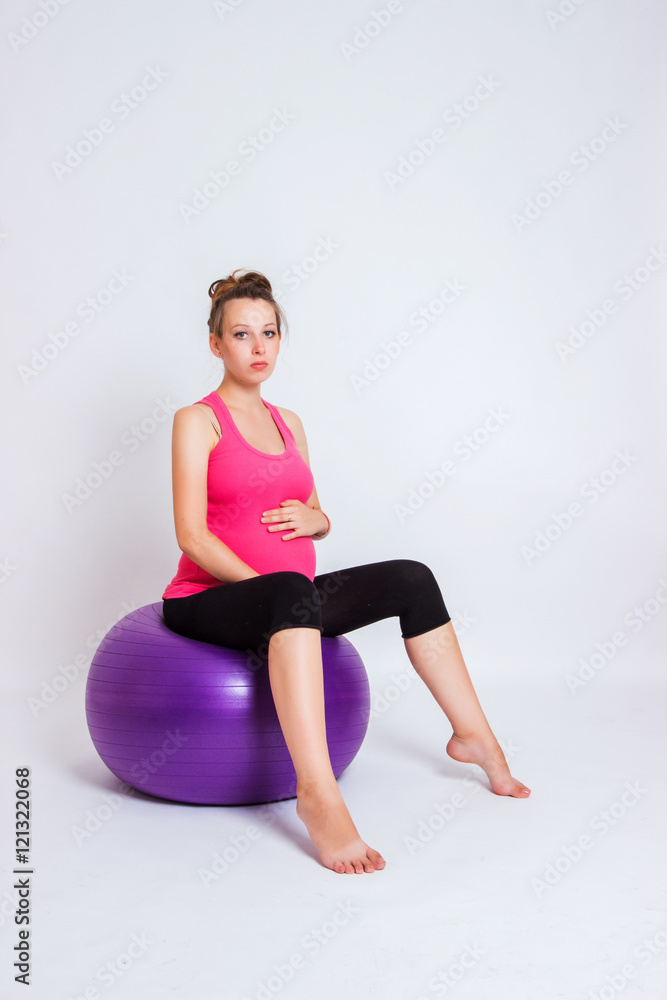 pregnant woman practicing yoga on a light background pregnant woman practicing yoga on a light background