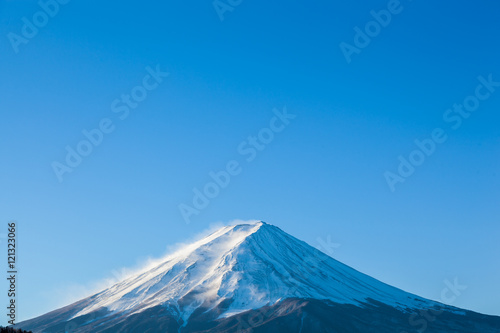Steamy Mount Fuji peak with clear blue sky in early morning sun