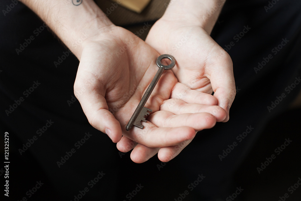 Hands holding old key