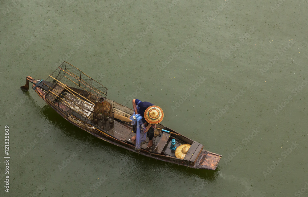 top view of fishing boat in river with a fisherman sitting net