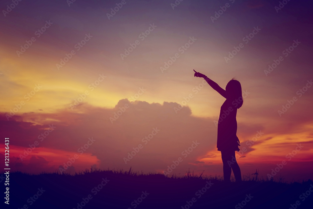 silhouette young woman pointing forward to Dream ahead in sunset