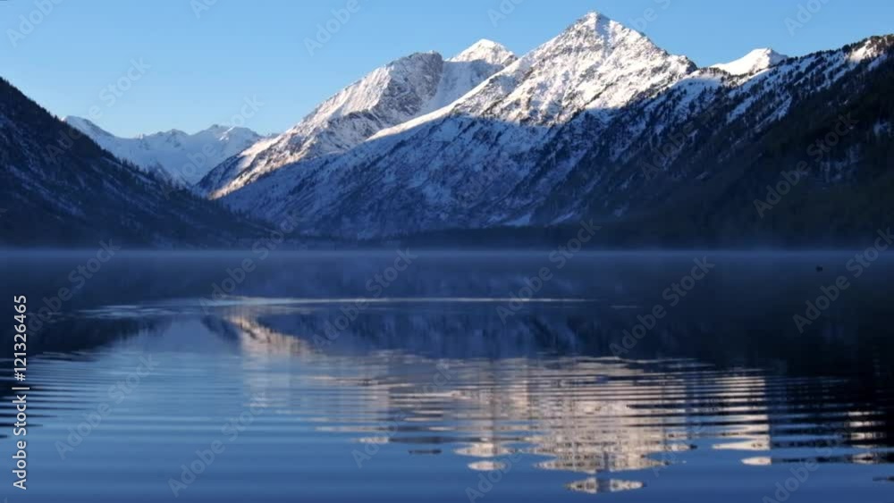 Circles on the water of Lower Multinskoe lake in the Altai Mountains on blue sky background. Circles on the water of Lower Multinskoe lake in the Altai Mountains on blue sky background.