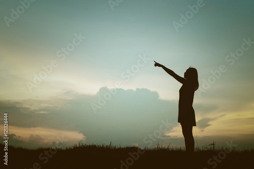 silhouette young woman pointing forward to Dream ahead in sunset