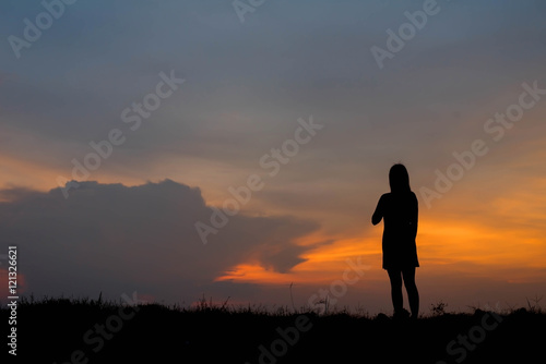 silhouette of woman  enjoys outdoor at sunset © stcom