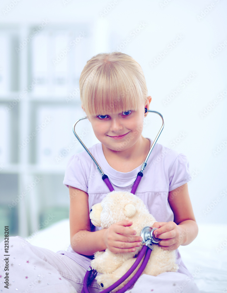 Little girl is examining her teddy bear using stethoscope Little girl is examining her teddy bear using stethoscope
