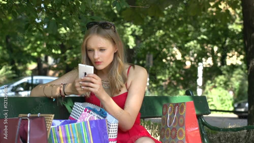 Shopper sitting in the park and browsing internet on smartphone
Shopper sitting in the park and browsing internet on smartphone