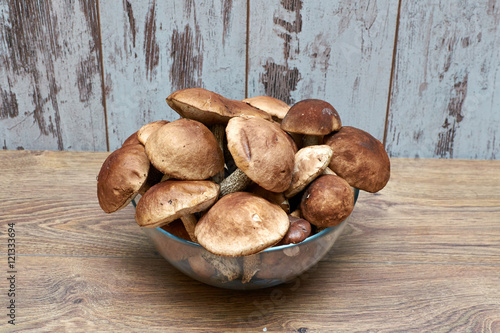 fall edible wild mushrooms boletus in a glass bowl on the oak table