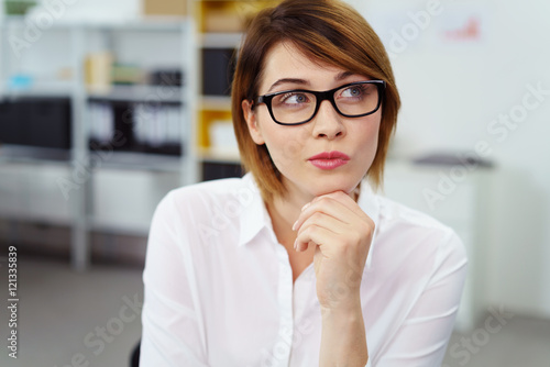 frau im büro schaut nachdenklich zur seite photo