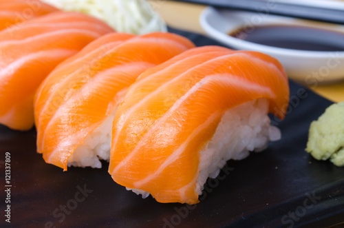 CloseUp Salmon sushi on a black plate. With wasabi and shoyu sau