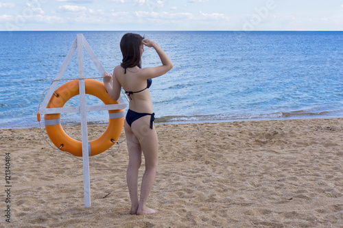 Girl on sea coast with lifebuoy