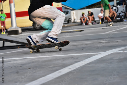 Skateboarding as extreme and fun sport. Skateboarder doing a trick in a city skate park.