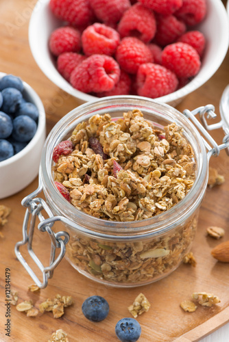 glass jar with homemade granola and fresh berries  top view