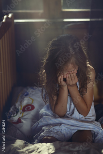 Crying child alone in a room
