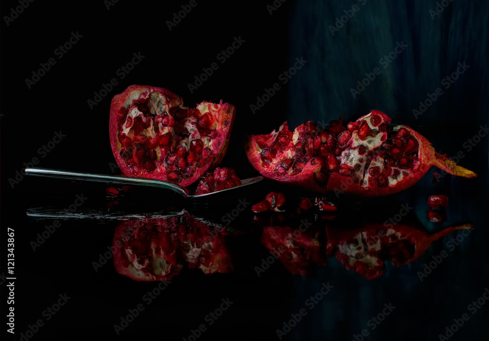 Pomegranate with spoon. Juicy, with black background Pomegranate with spoon. Juicy, with black background