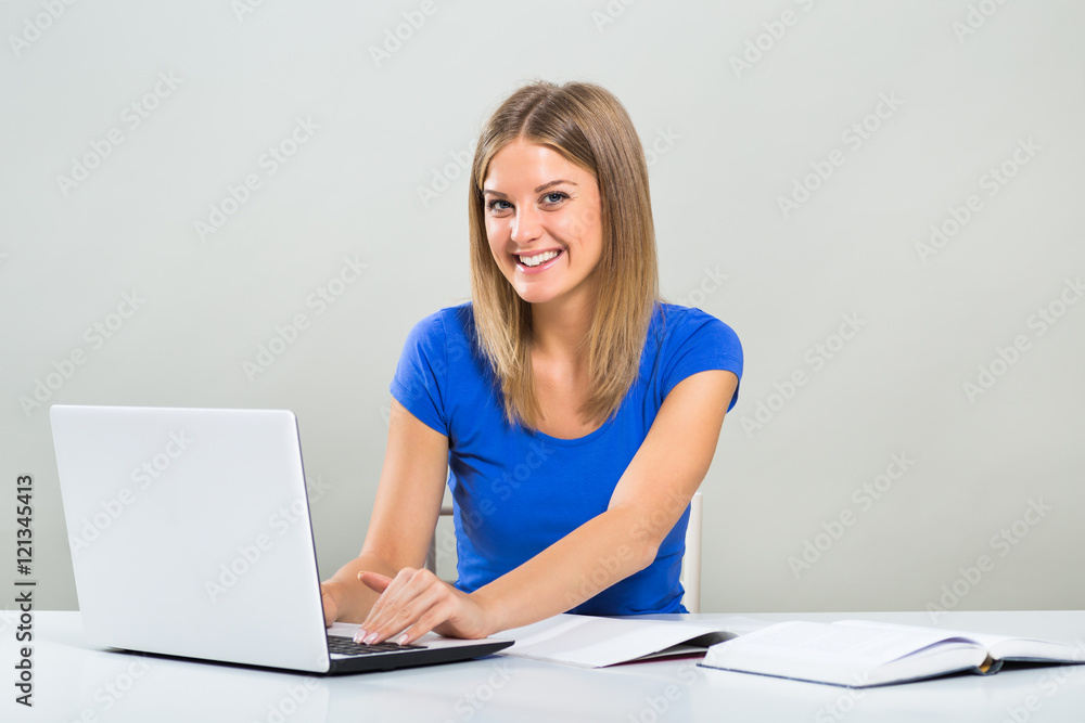 Portrait of beautiful female student using laptop and studying.
Portrait of beautiful female student using laptop and studying.