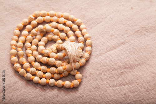 Canvastavla Closeup of rolled Indian japa mala chanting beads on woolen texture