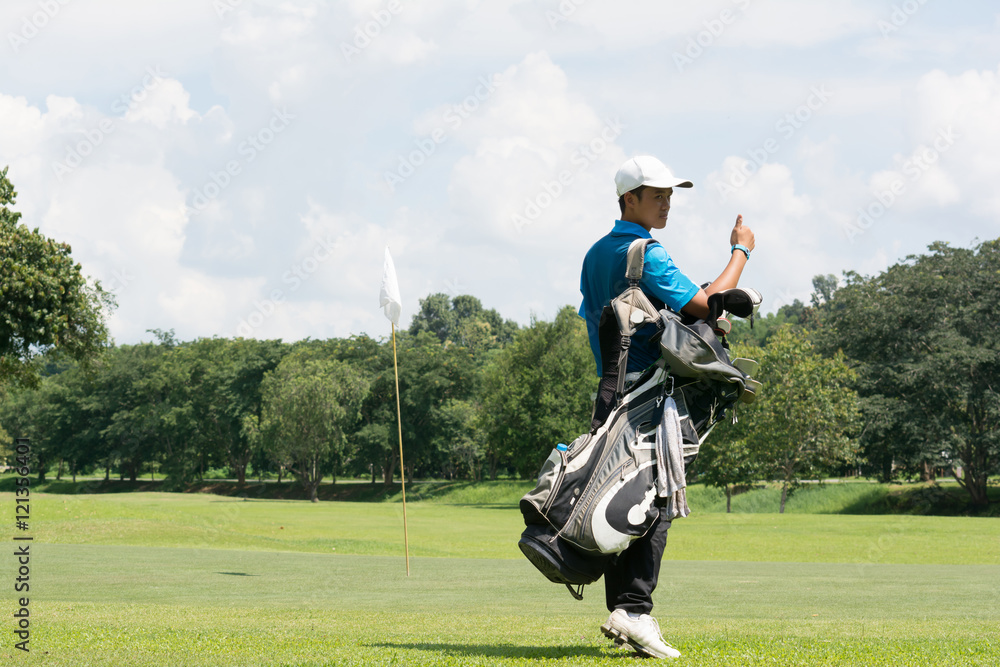 Handsome asian golf player man with his bag on golf course with