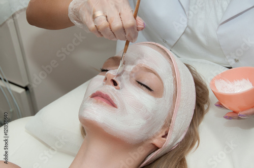 Hardware cosmetology. Lovely young woman with cream mask in a beauty parlour.