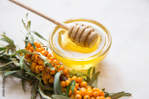  sea buckthorn and honey on a light background. Selective focus