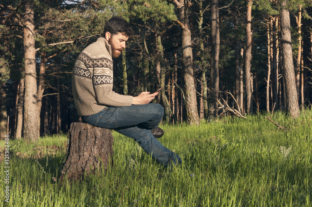 Obraz premium Young man in the woods enjoying a sunny afternoon
