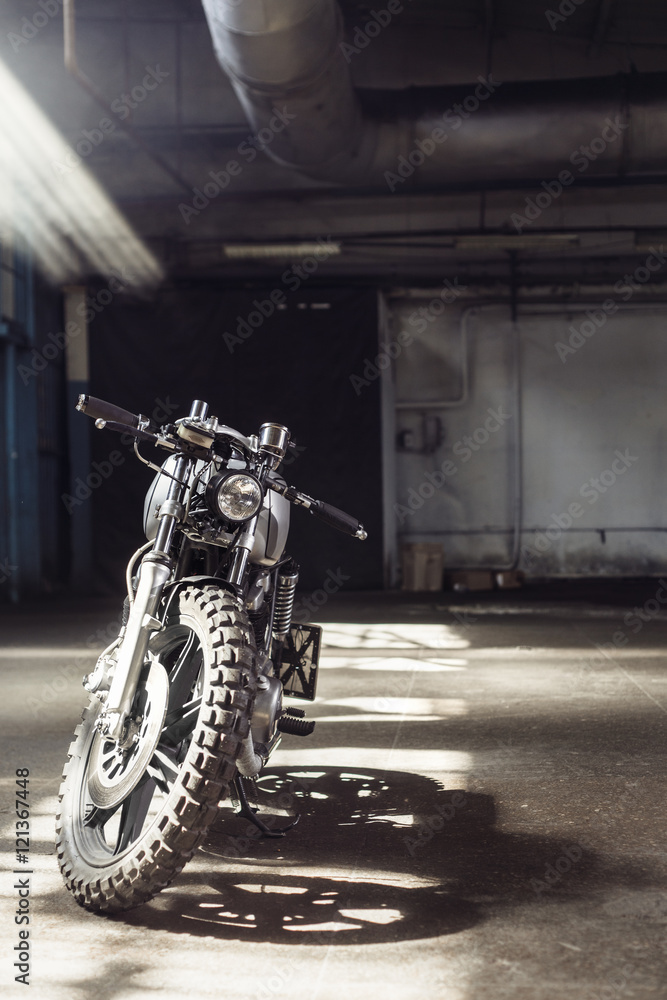 motorcycle standing in dark building in rays of sunlight motorcycle standing in dark building in rays of sunlight