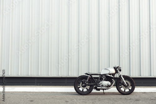 motorcycle standing in dark building in rays of sunlight photo