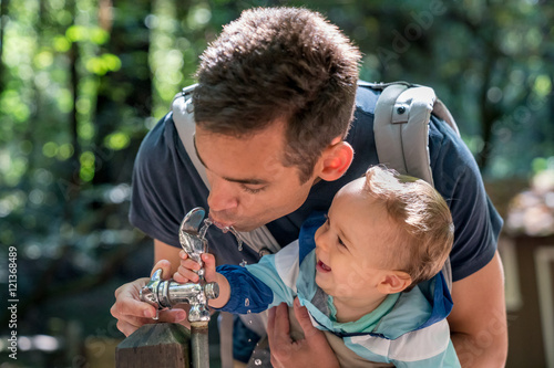 10 month old baby boy at water fountain with hispanic dad