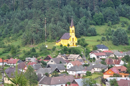 Slovakian village with a yellow church, Smolnicka Huta, Slovakia photo