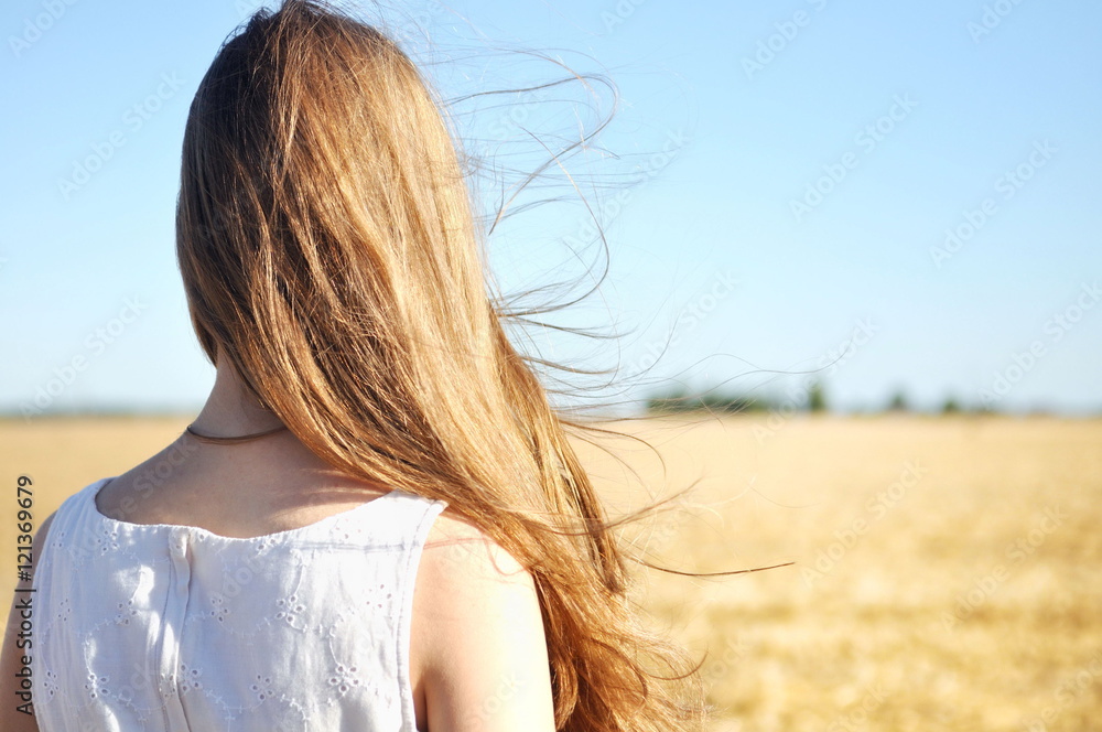 Girl stands outdoors, wind flutters her long hair Girl stands outdoors, wind flutters her long hair