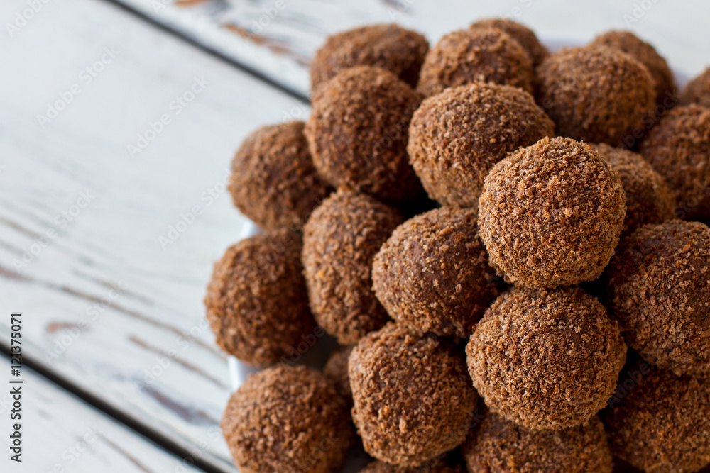 Brown colored sweets. Ball shaped candies with crumbs. Dessert with cocoa powder. Sweet dish high in calories. Brown colored sweets. Ball shaped candies with crumbs. Dessert with cocoa powder. Sweet dish high in calories.
