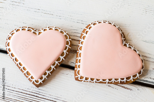 Two heart-shaped cookies. Biscuits on white wooden background. Small romantic present. Flavor of happiness.
