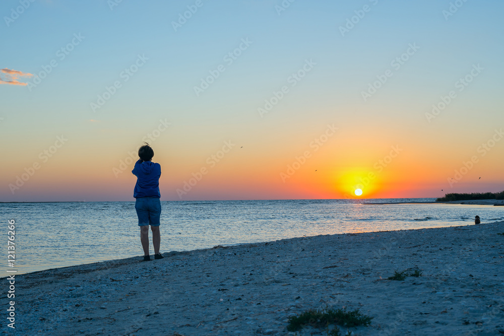 Woman photographs sunset