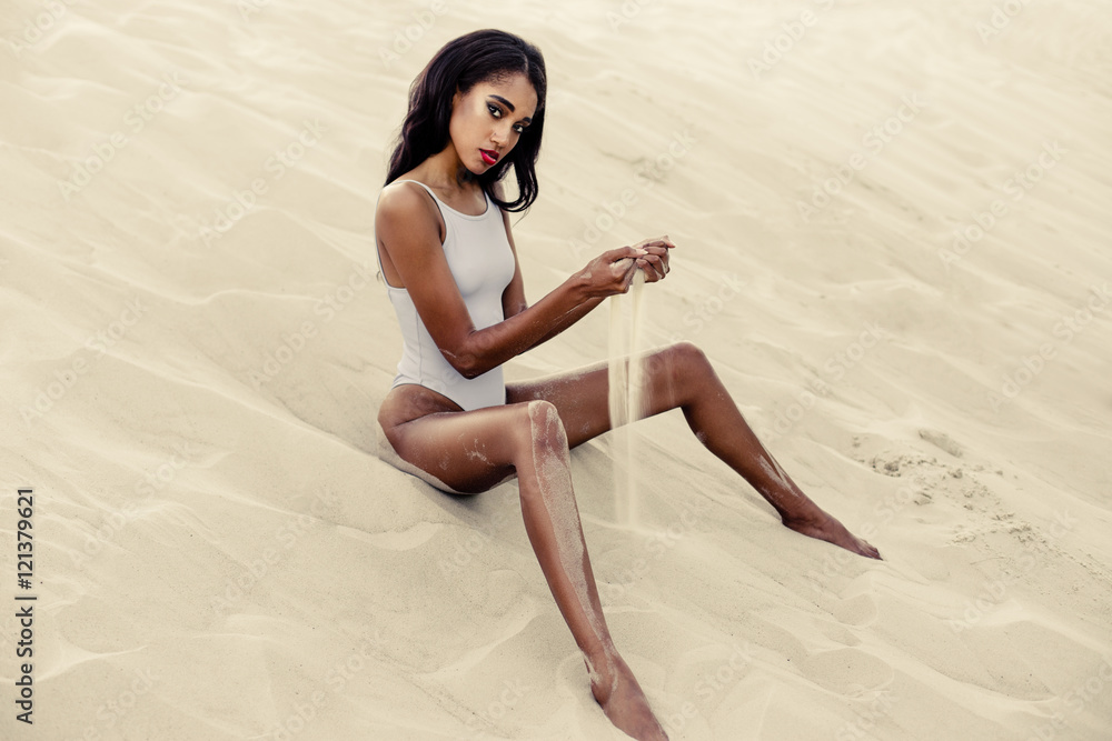 Fototapeta premium Attractive African-American girl in swimwear on sandy beach 