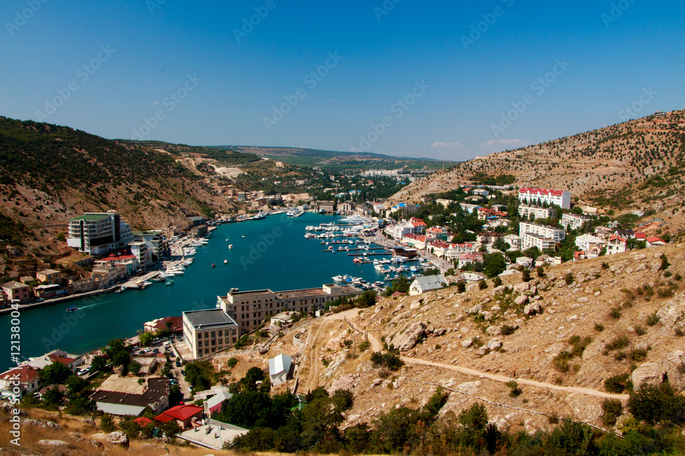 Panorama view of Balaclava from the ancient fortress Chembalo. Balaclava Bay with yachts in bright sunny day. Crimea, Rusiia.