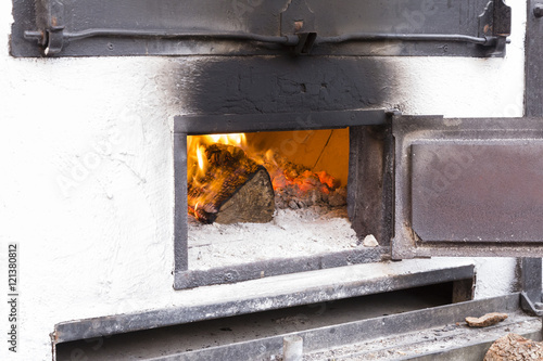 white wood oven with the door open iron and wood burning