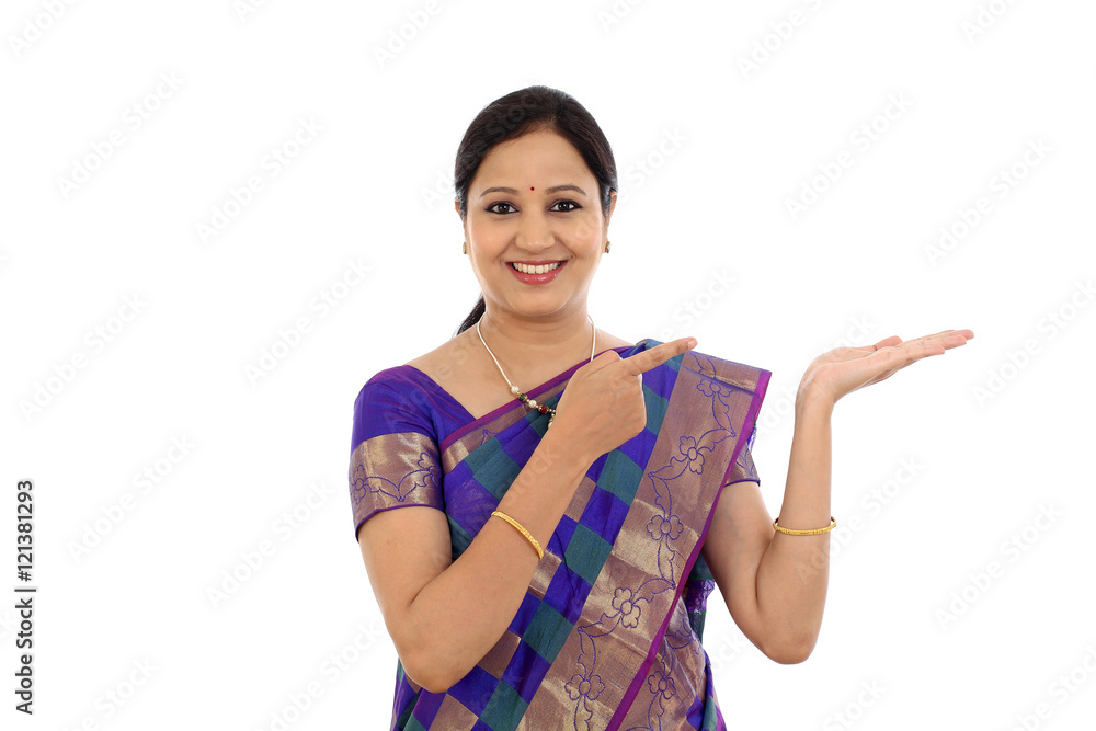 Happy young traditional woman showing copy space against white Happy young traditional woman showing copy space against white