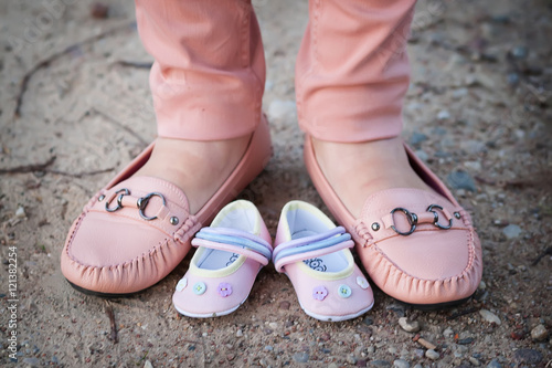 Shoes of mother and expected baby