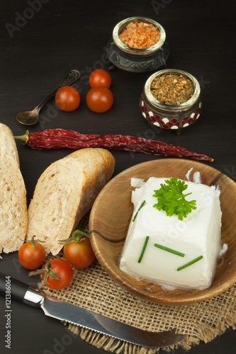 Goat cheese with fresh tomatoes on wooden table. Fresh cheese and pastries. Diet food. Goat cheese with vegetables. 