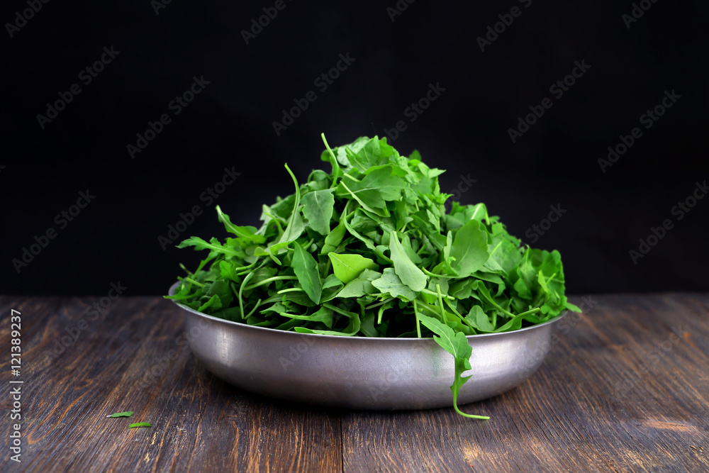 Concept of healthy eating, vegetarian diet. Green rock salad in aluminium bowl. Selective focus. Special light. Concept of healthy eating, vegetarian diet. Green rock salad in aluminium bowl. Selective focus. Special light.