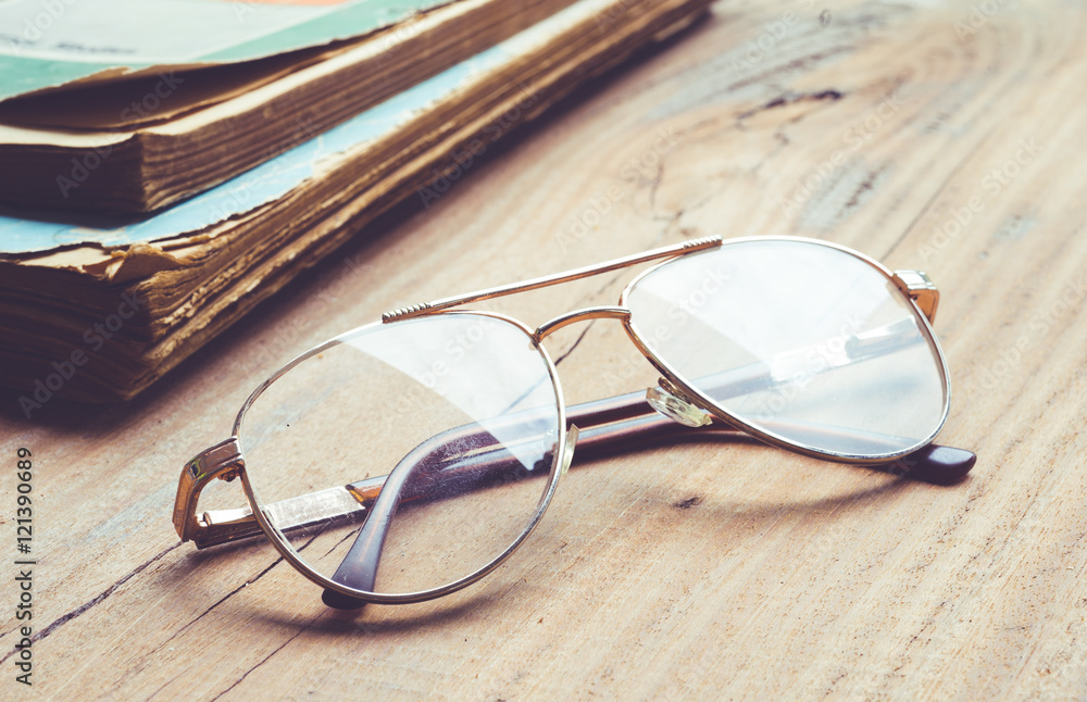 Glasses and old books on wood table background . Glasses and old books on wood table background .