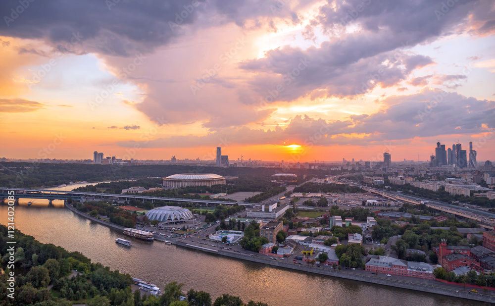 Panoramic view of sunset above Moscow city and cloud reflections in river with traveling boats